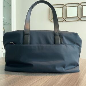 The Away “Everywhere Bag” in navy blue (nylon) with black straps. Like new.